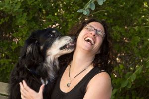 Dr. Jane Shaw, head of CSU Veterinary Communication for Professional Excellence, gets a kiss on the face from a dog.
