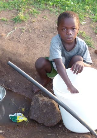 Tanzanian boy collecting water