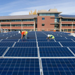 Contractors with Namaste Solar install an array of solar panels capable of powering 14 homes on the roof of Colorado State Universityâ€™s Braiden Hall, October 24, 2014.