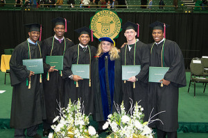 Dean Ann Gill congratulates student-athlete graduates at a College of Liberal Arts commencement ceremony.