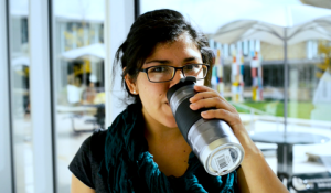 A student drinks from a reusable coffee mug