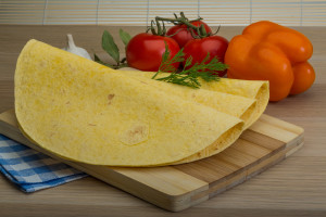 Mexican tortilla with dill branch on the wooden background