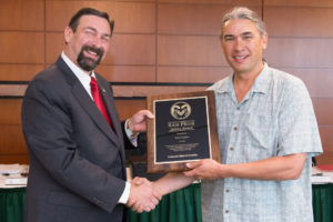 Colorado State University President Tony Frank presents Natural Resource Ecology Laboratory research scientist Paul Evangelista with the Ram Pride Service Award for his work supplying textbooks to Ethiopia's Hawassa University.
