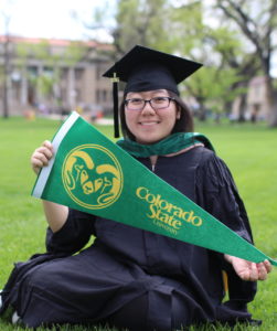 Girl with Colorado State pennant sitting on Oval.