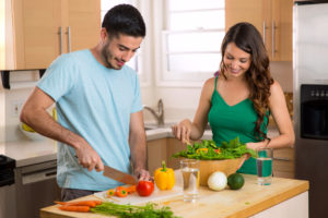 Attractive man and woman prepping low calorie dinner in kitchen very health conscious