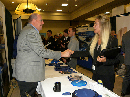 student shakes employers hand at career fair