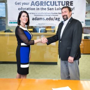 Adams State University President Berverlee McClure and Colorado State University President Tony Frank shake hands after signing the MOU that launches a new degree program in agriculture.