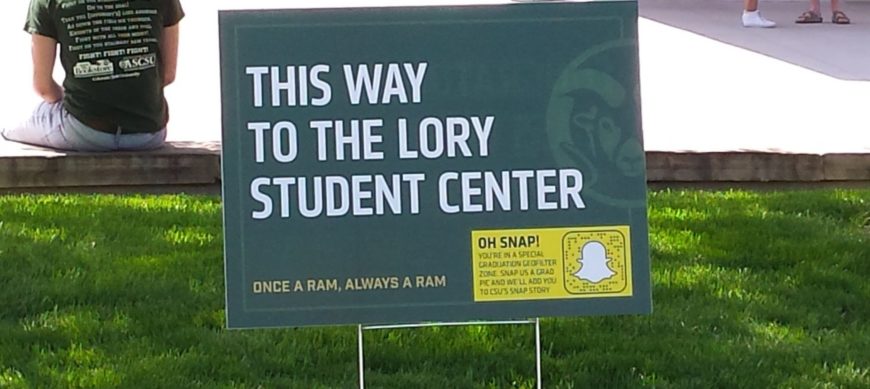 A sign in the grass reads "This way to the Lory Student Center"