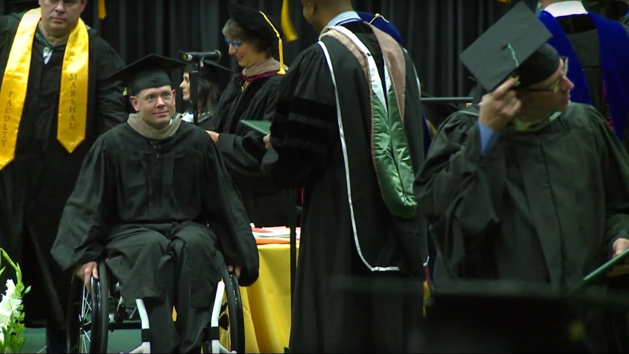 Kevin Hoyt wheels offstage in his cap and gown after getting his diploma in his wheelchair