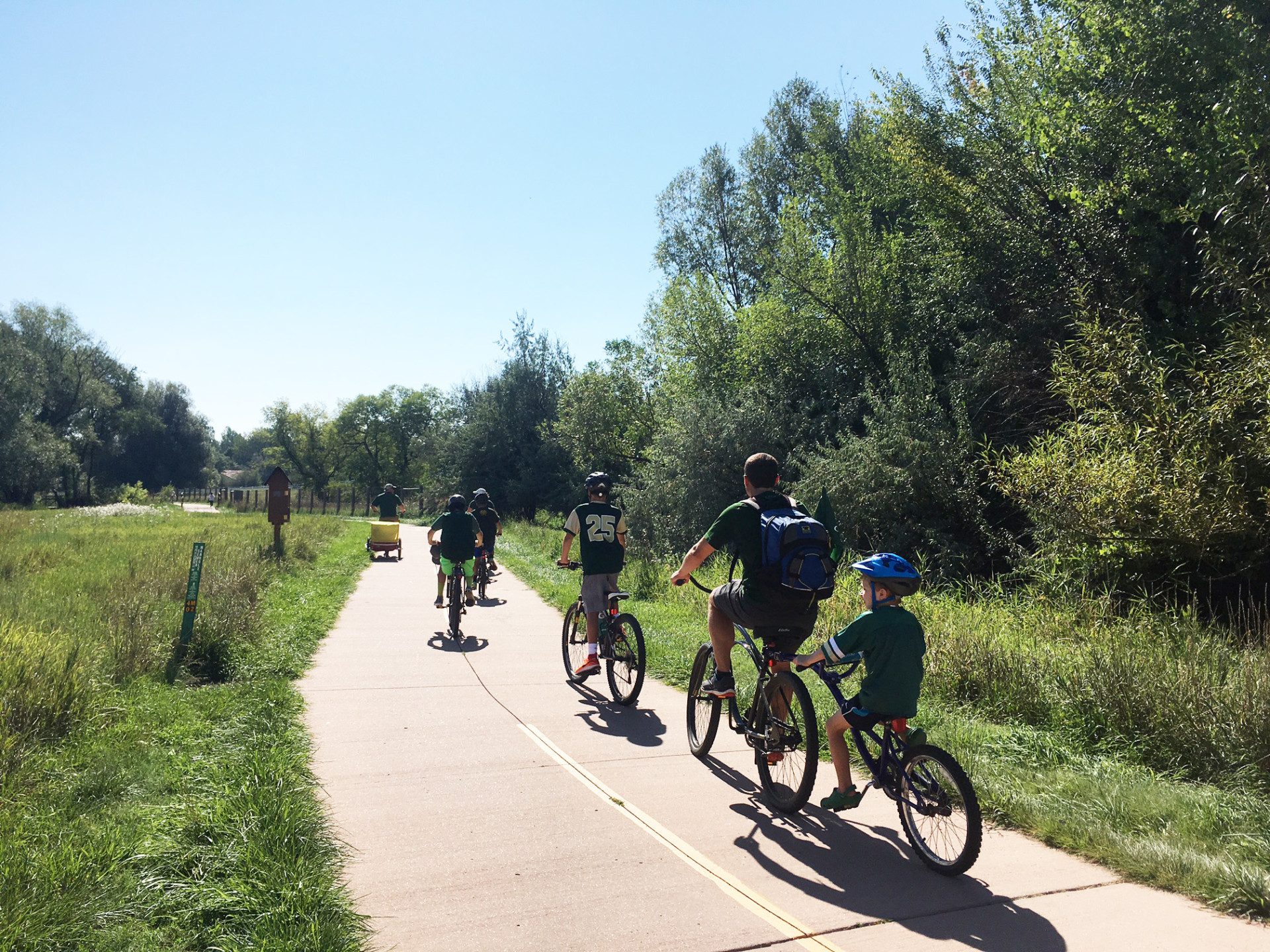 Color photo of a family biking to first CSU football game on the Spring Creek Trail