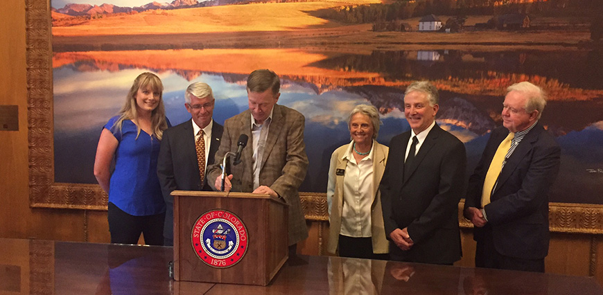 Gov. John Hickenlooper signs the Veterinary Education Loan Repayment Program on June 5, 2017, as Dr. Lora Bledsoe, Dr. Mark Stetter, Rep. Joann Ginal, Dr. Sam Romano, and Leo Boyle look on. (Photo provided by Richard Schweigert)