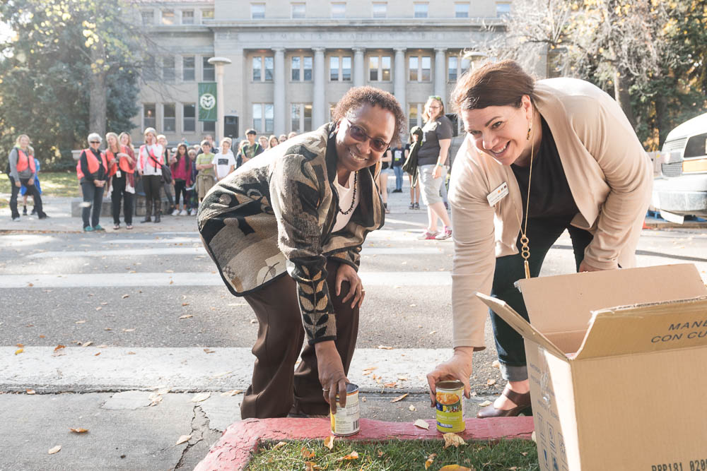Colorado State University Vice President for Student Affairs Blanche Hughes and Food Bank for Larimer County Development Director Heather Buoniconti place the first cans at the 31st annual Cans Around the Oval food drive, October 18, 2017.