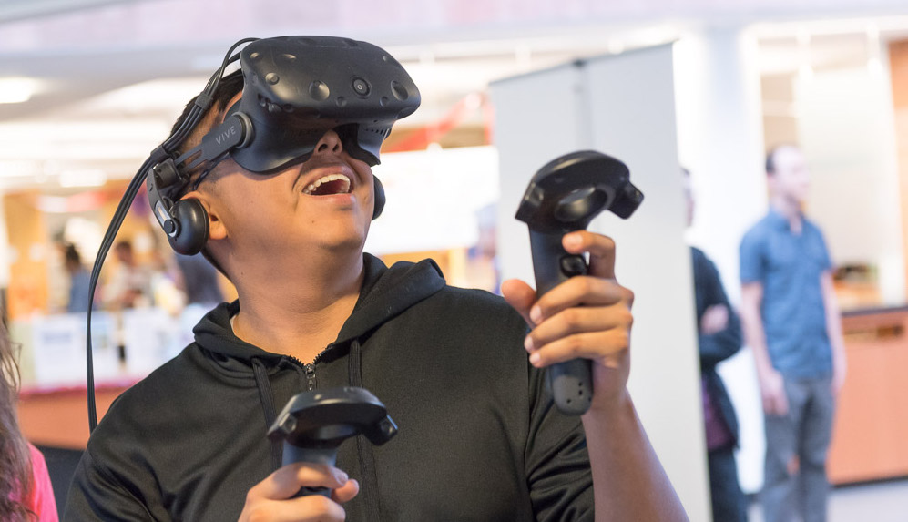 Student with virtual reality goggles and controllers