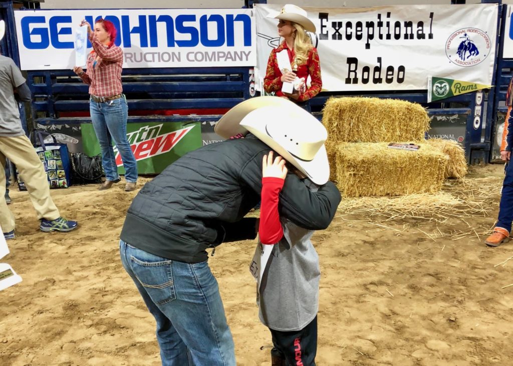 Cowboy hugs participant at Exceptional Rodeo.