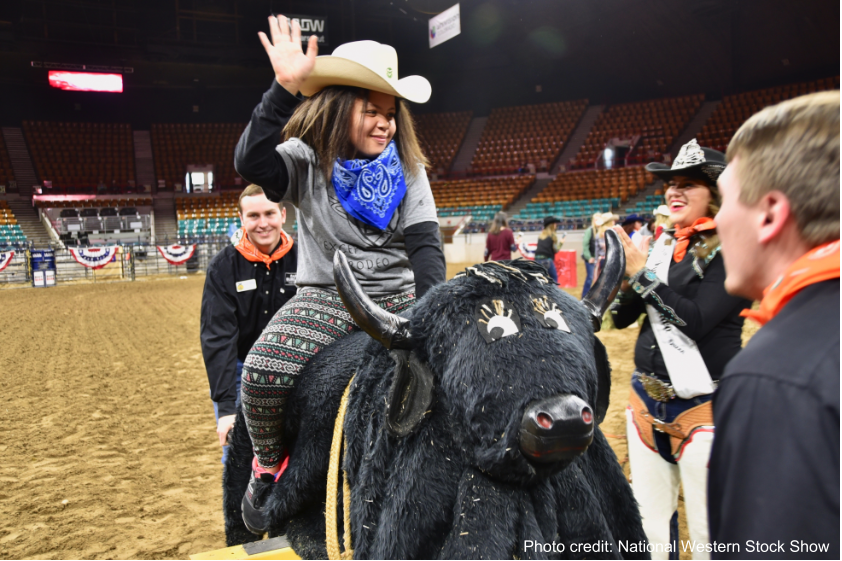Exceptional Rodeo participant riding a fake bull.