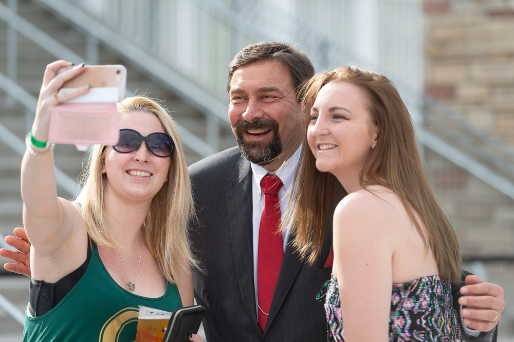 Two students take selfie with Tony Frank