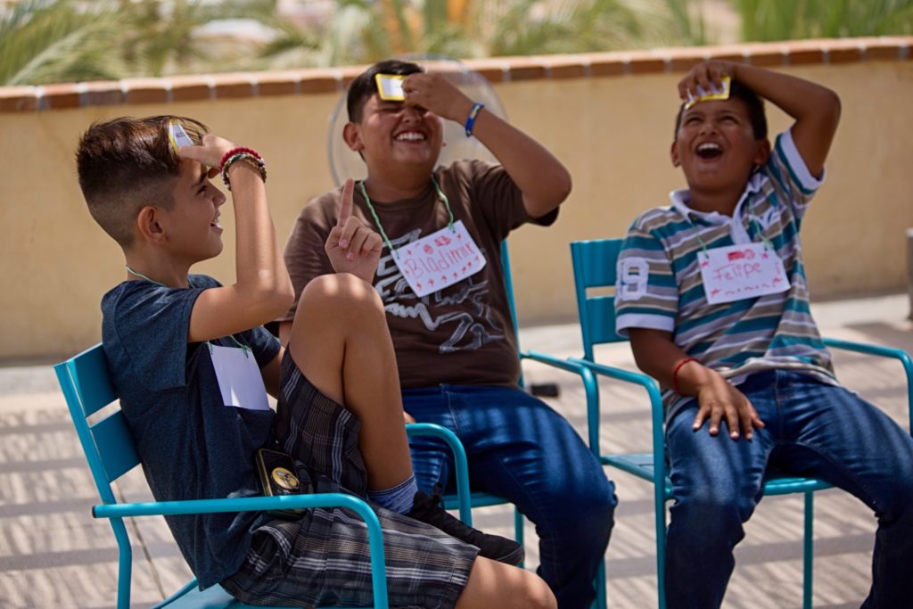 Three young boys laugh as they play game during Kids Do It All program at CSU Todos Santos Center.