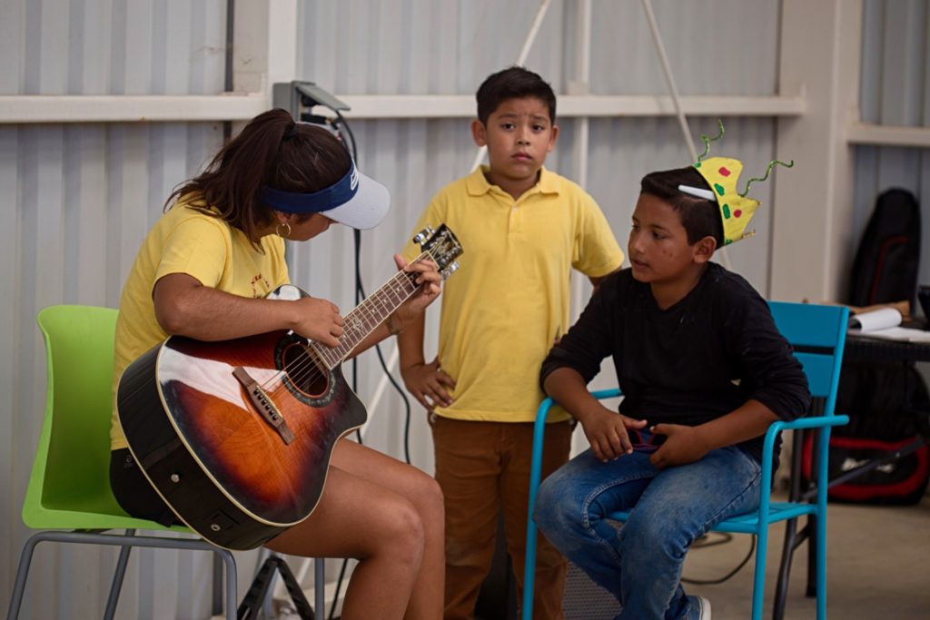 Three youth participating in the Kids Do It All program play music for crowd at the CSU Todos Santos Center.
