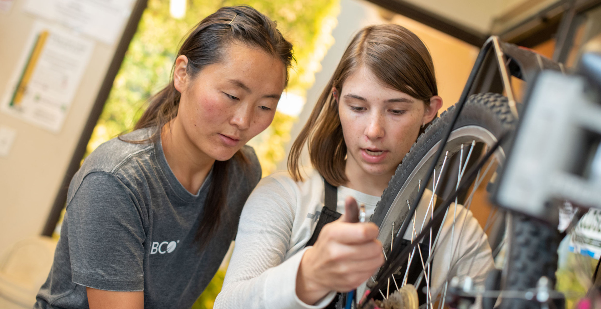 Bailey Richards, a mechanic at The Spoke, a student-run bike repair shop at Colorado State, assists a fellow student with a repair.