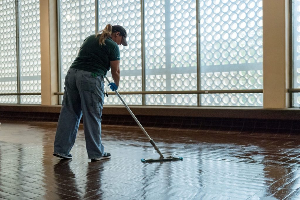 Facilities employee mopping a floor in Clark Building