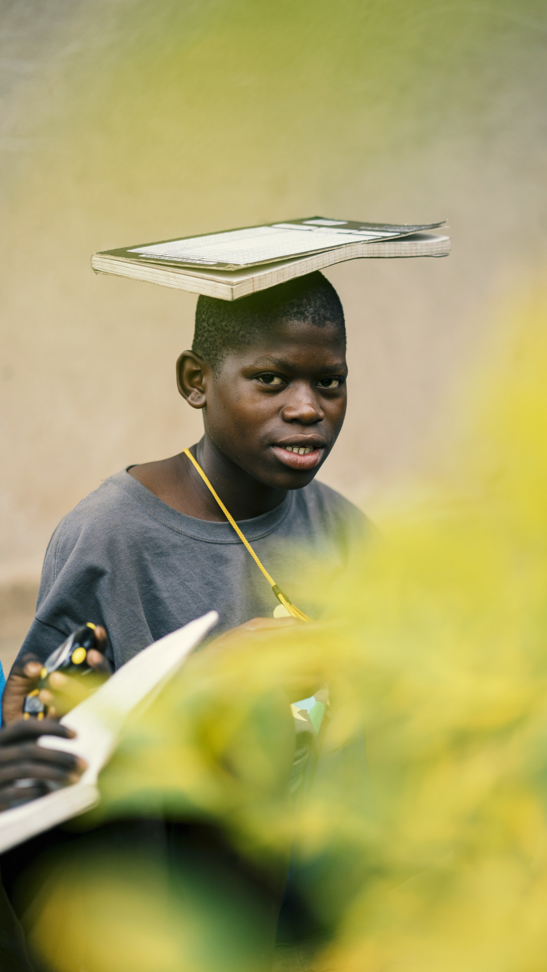 Student balancing notebook on head