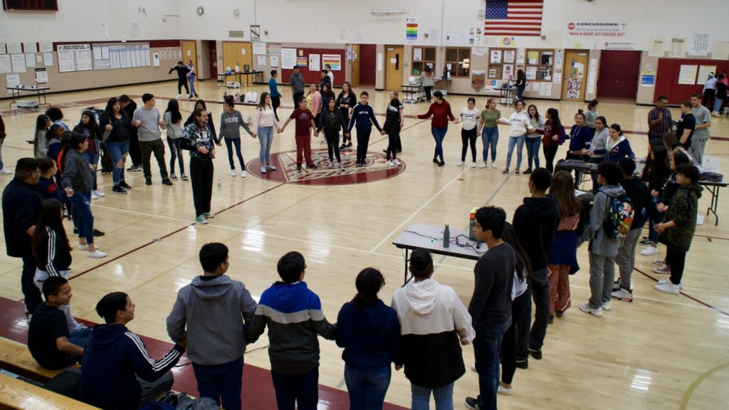 Little Shop of Physics 11th-grade mentors from Bruce Randolph School participate in sound connection experiment with large group of younger students.