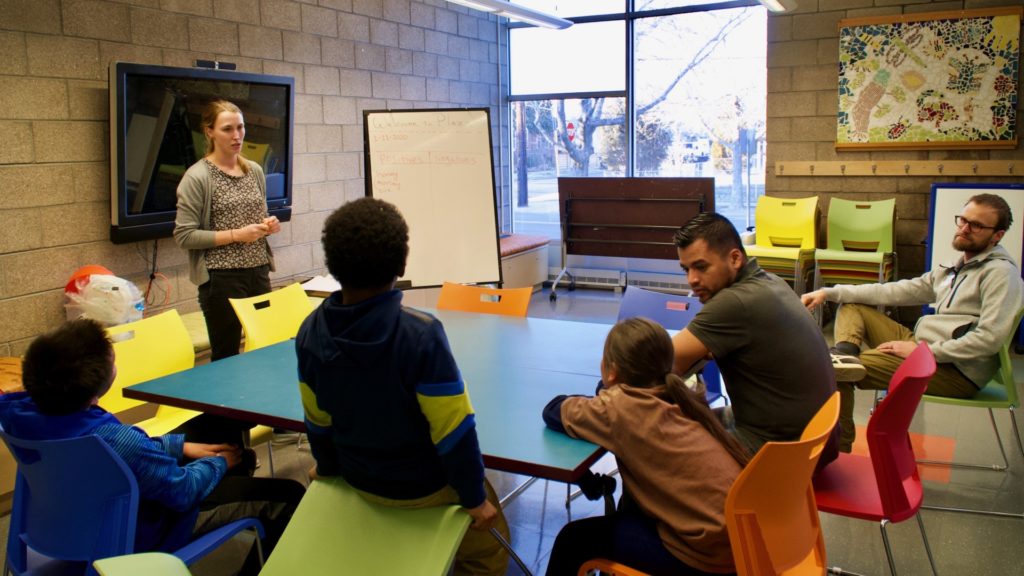 CSU Denver Extension/4-H Agent Merielle Stamm (standing) leads STEM workshop on entomology for youth, with support from Librarian Liam Gray (far-right) and Library Program Associate Armando Pineche Rosales (left of Gray) at Valdez-Perry Branch Library in north Denver.