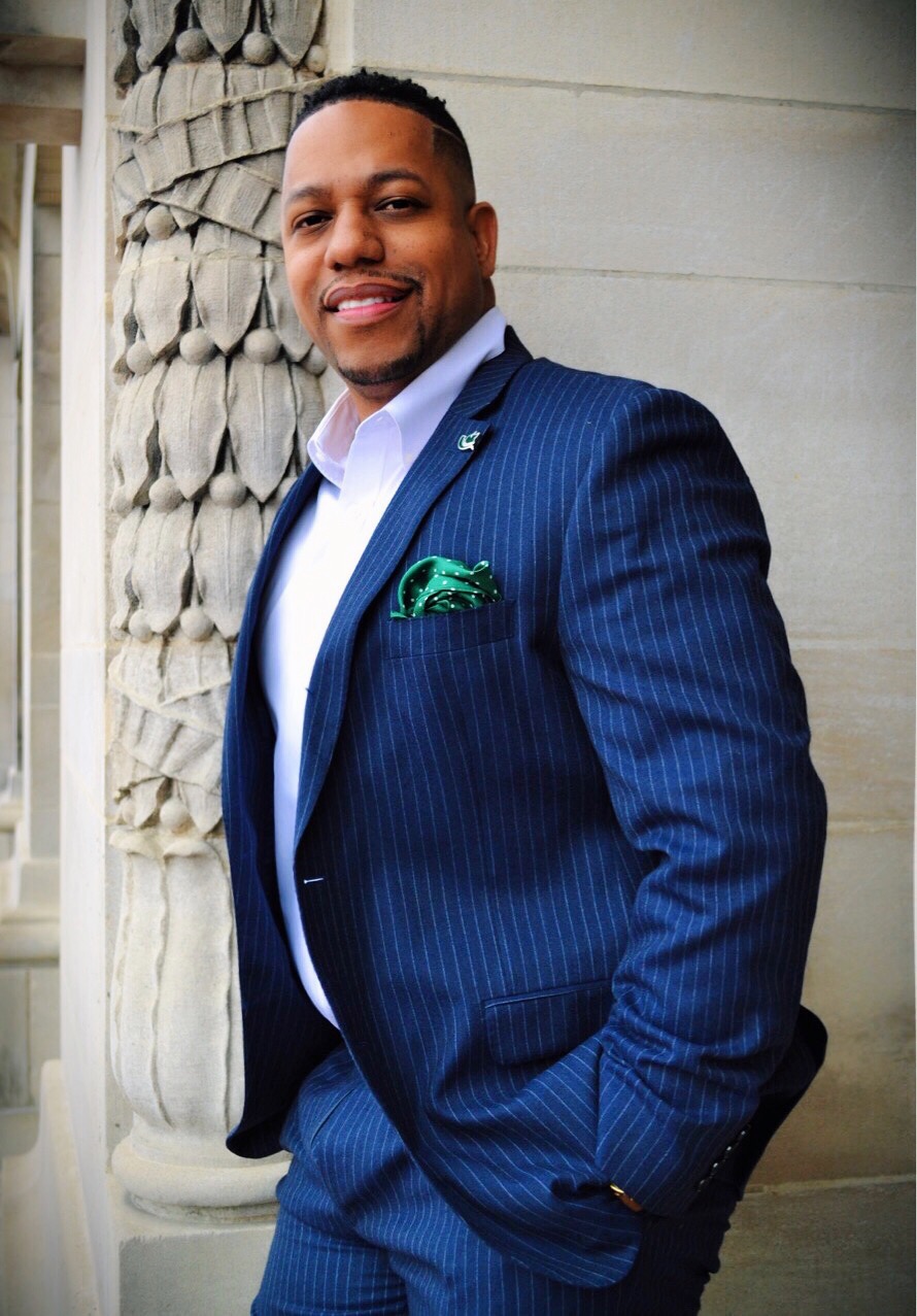 Man in a blue suit with a green pocket square