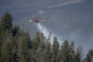 A Skycrane Type 1 helicopter drops water on the Cameron Peak Fire one mile east of Colorado State University’s Mountain Campus