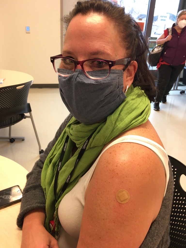 Person with bandage over vaccine site