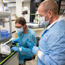 researchers in lab wearing masks