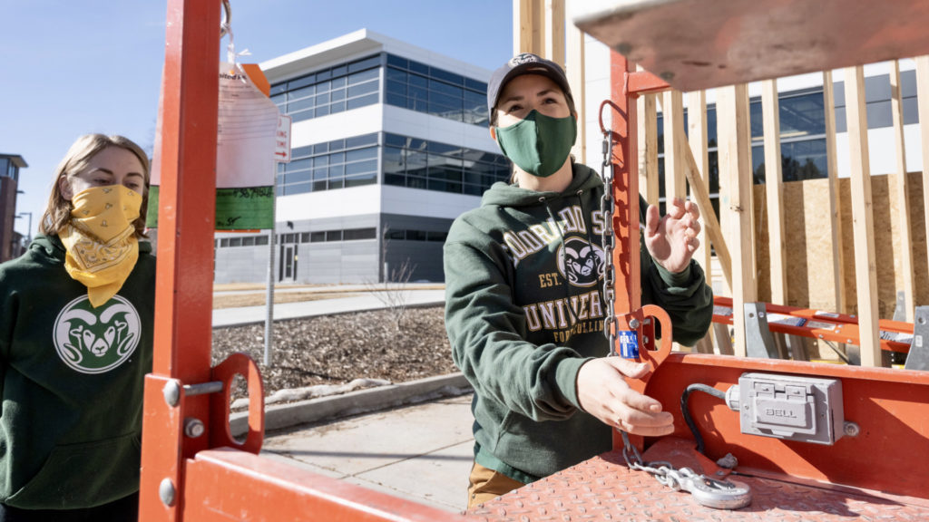 Maria Delgadostands next to student while assisting in the construction of a tiny house on wheels at the Nancy Richardson Design Center, March 6, 2021.