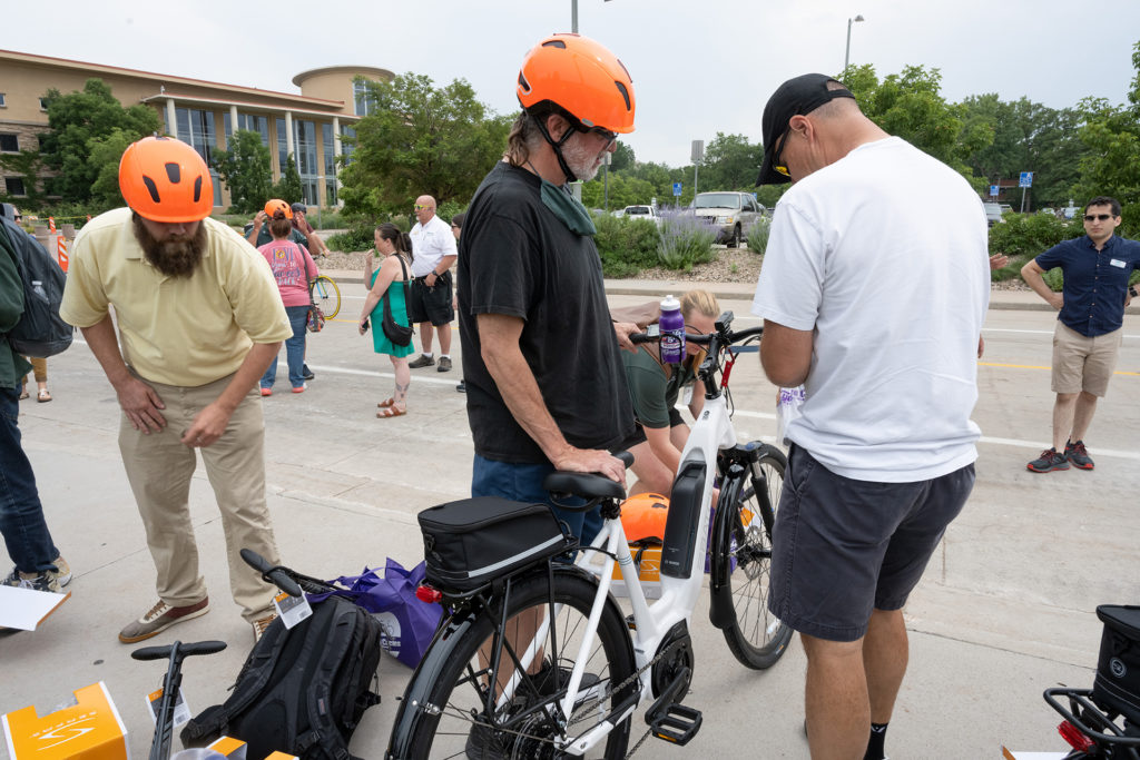 CSU employee with orange helmet prepares to ride e-bike