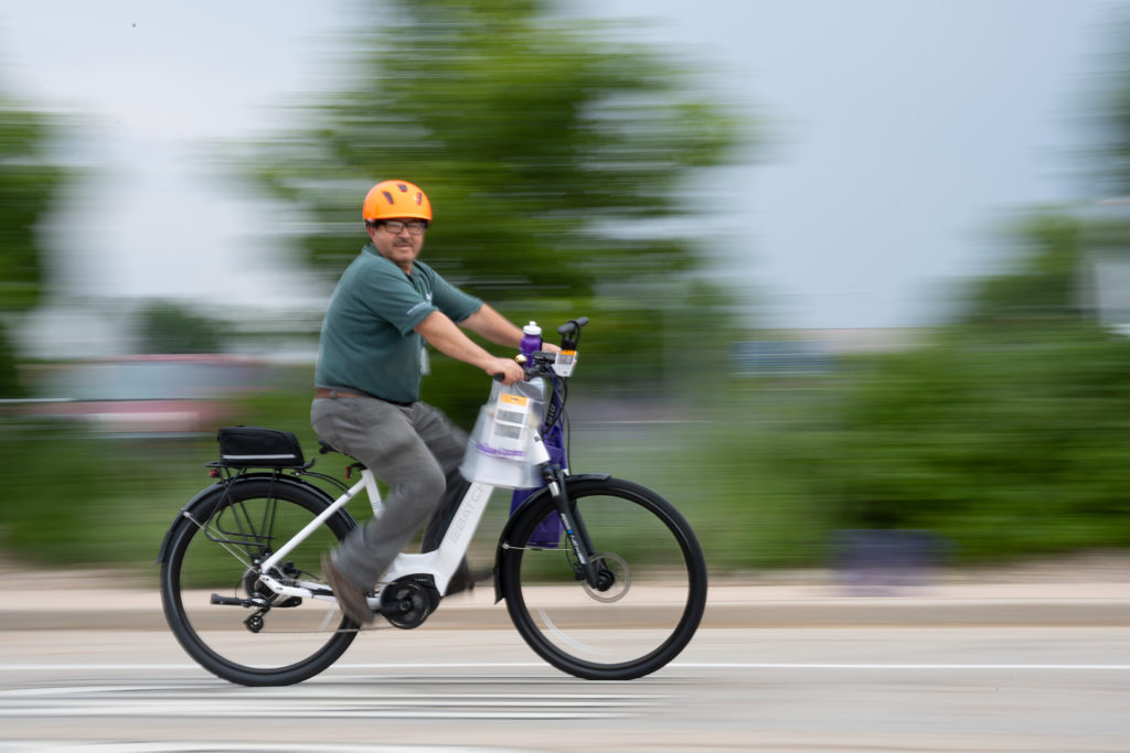A CSU employee riding his e-bike