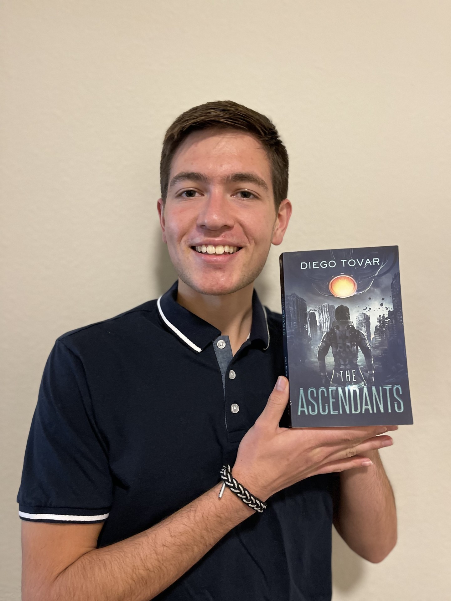 Diego Tovar holds up a copy of his book, The Ascendants
