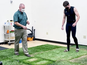 Raoul Reiser tells Michael Boyle what kind of football-type cut to make on the force plates below the artificial turf.
