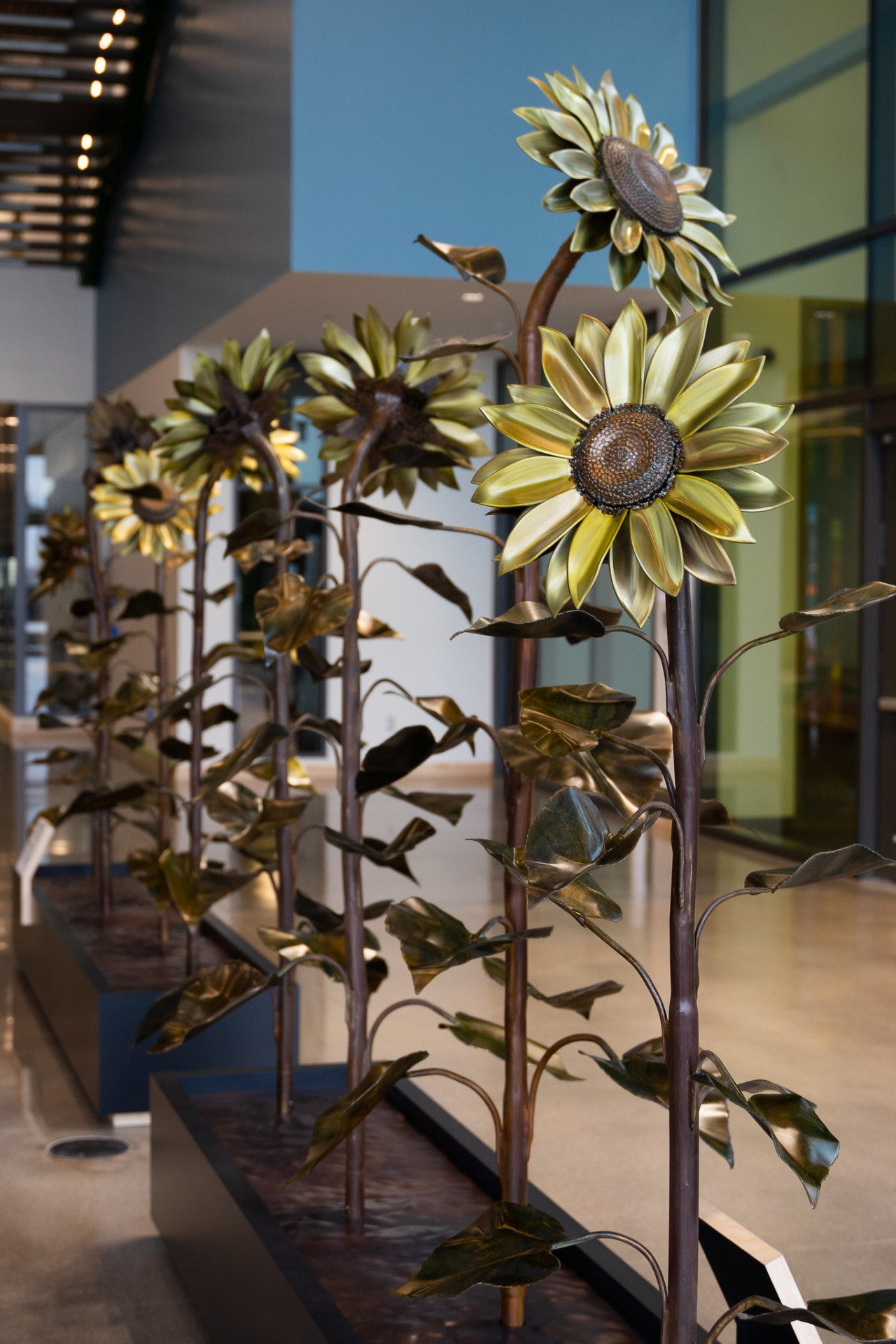 Metal sunflower sculptures in a row.