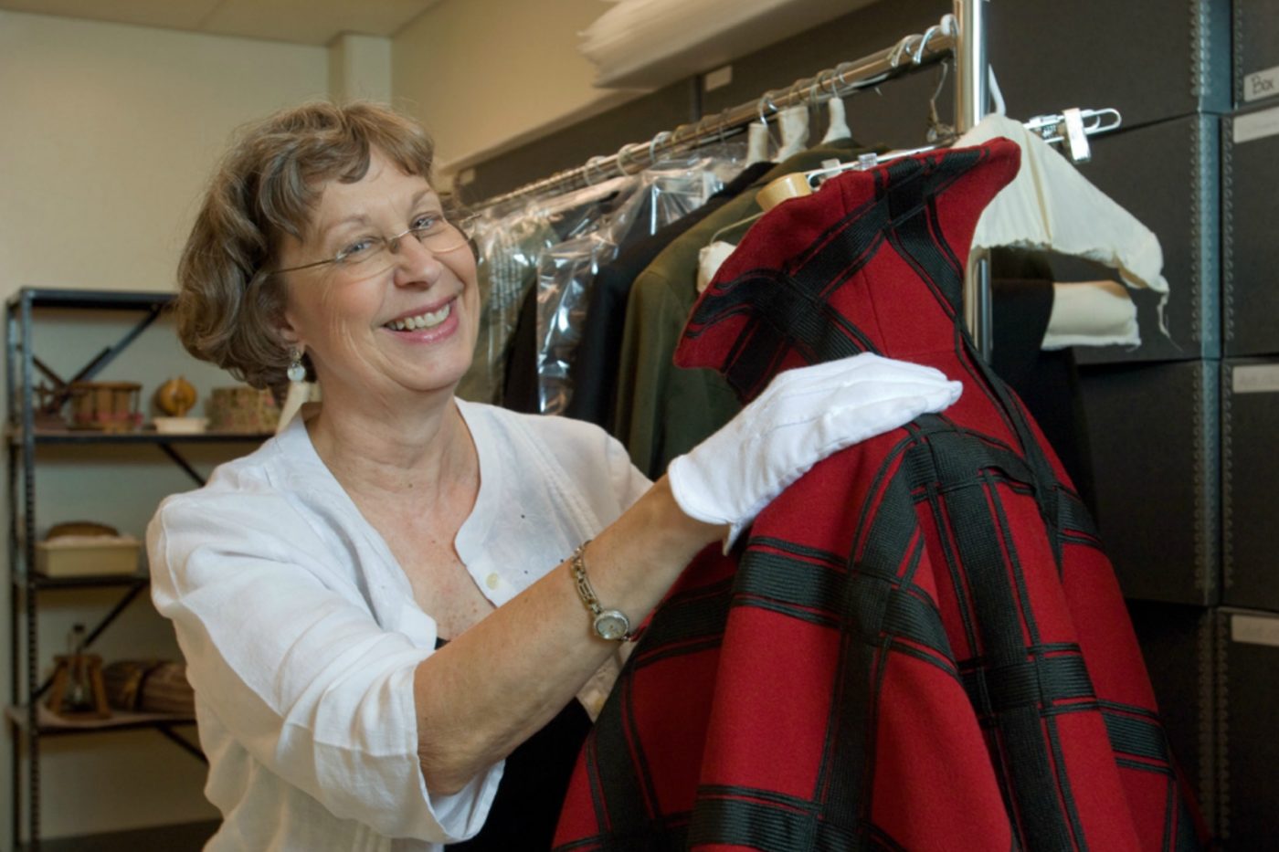 Linda Carlson with an artifact from the costume and textiles collection in the Gifford storage facility circa 2007.