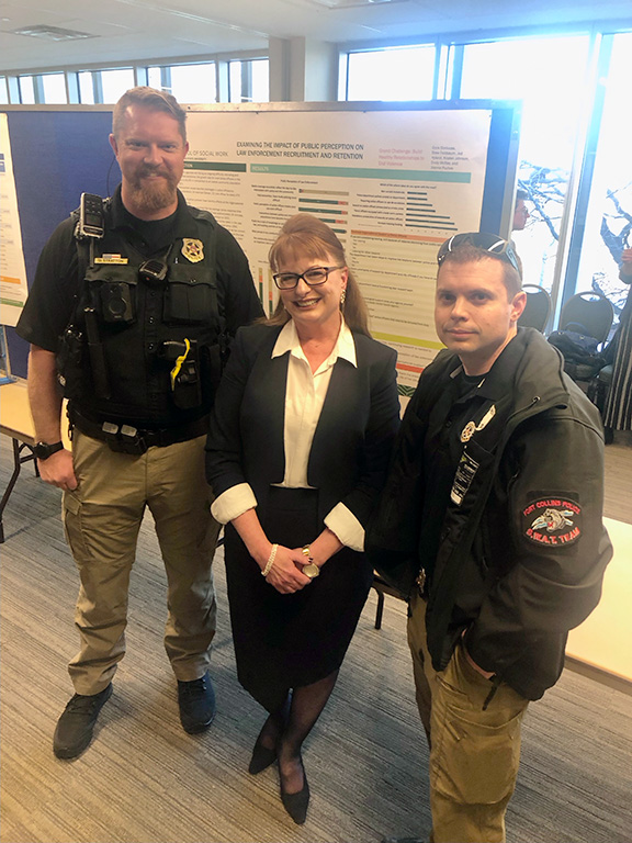 Fort Collins police officers Dean Stratton (left) and Bryce Younkin (right) attended the poster presentation with Kristen Johnson.