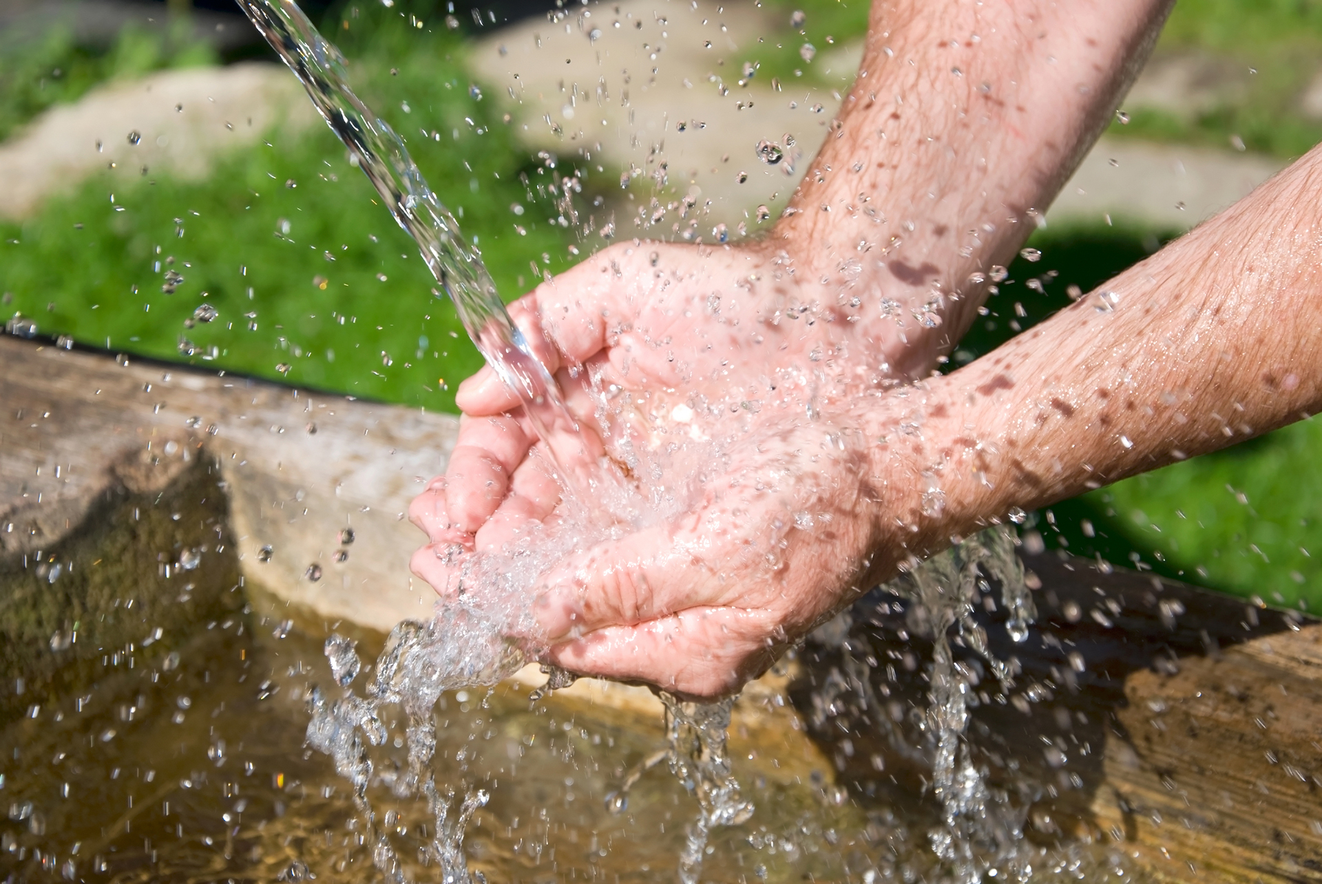 A man's hands catch a stream of water