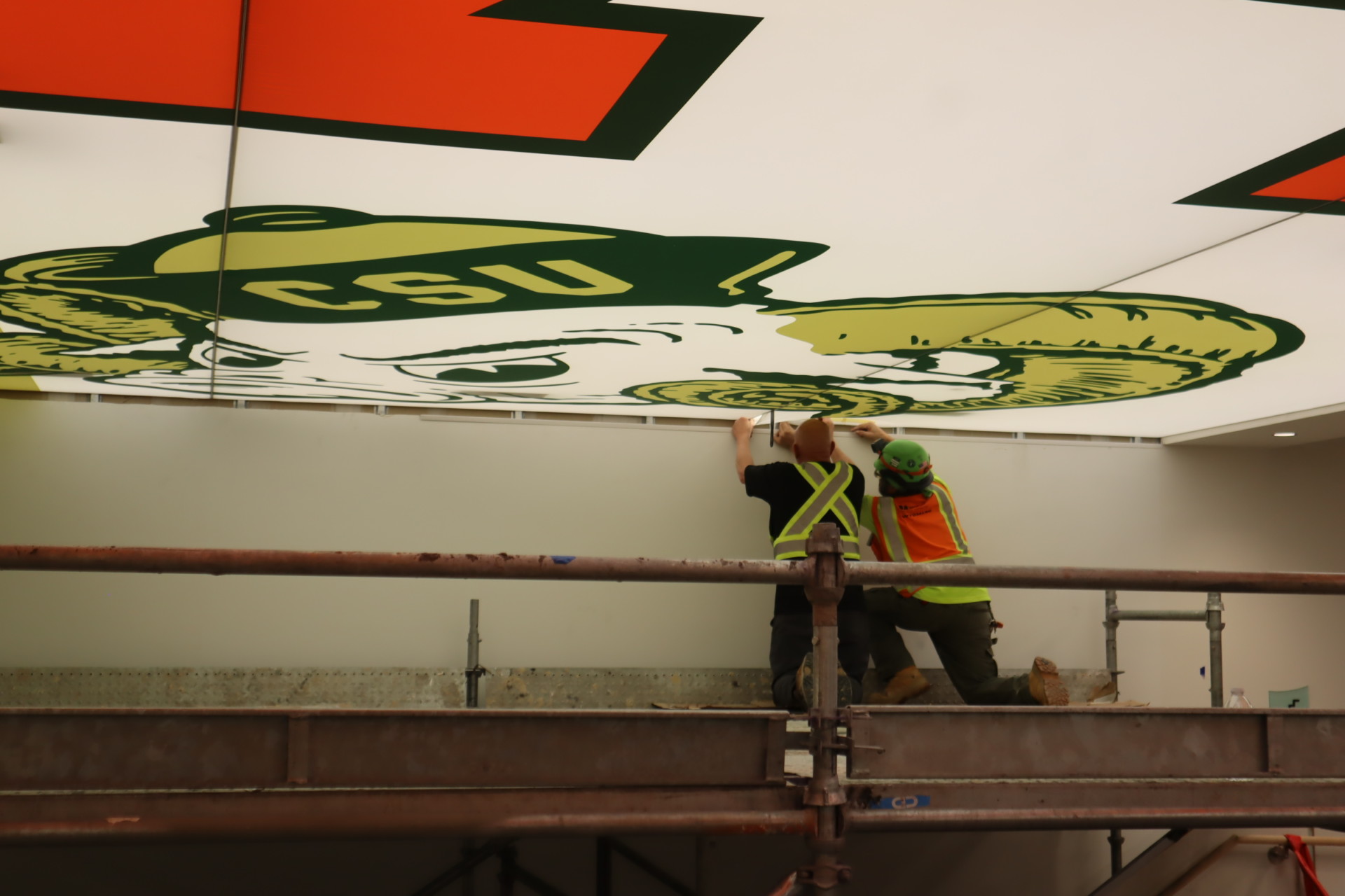 Workers applying ceiling art