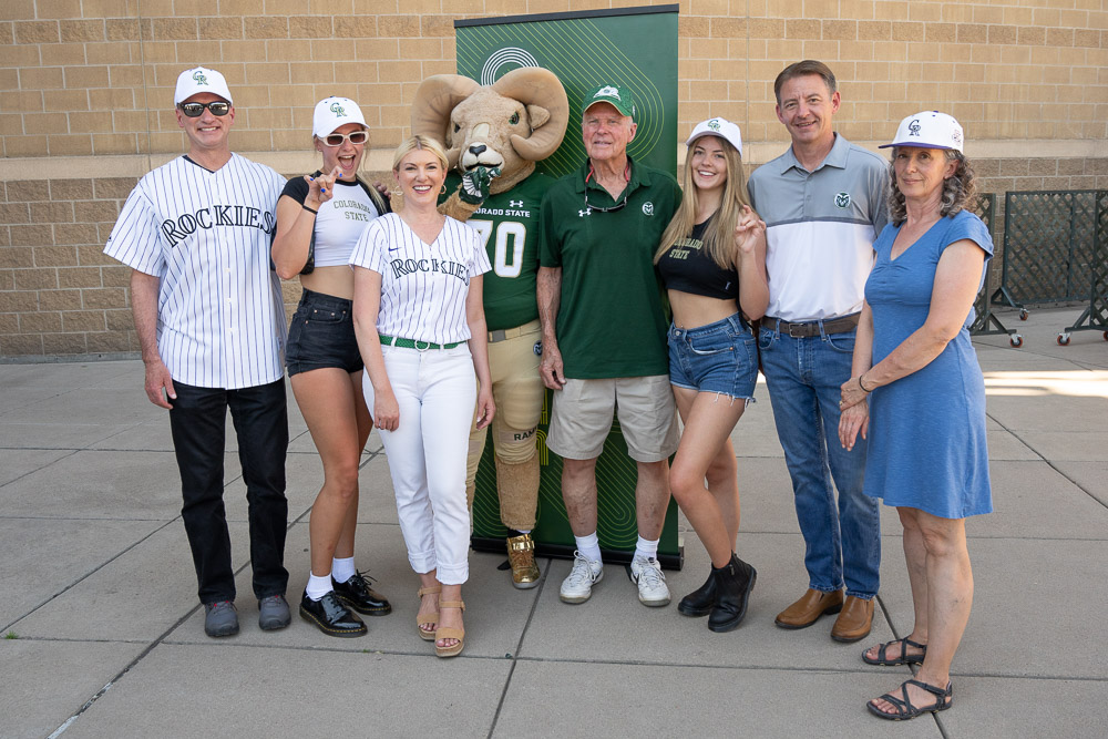 CSU President Amy Parsons poses for a photo with CAM the Ram and CSU community members at 2023 Rams at Rockies
