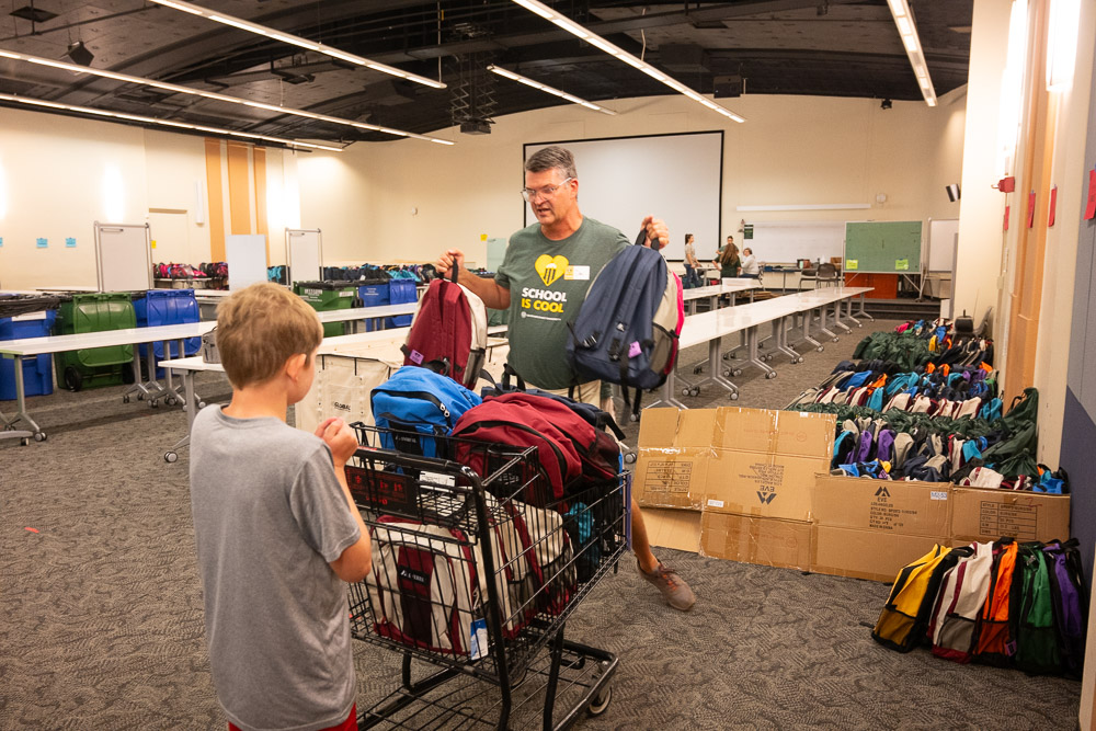Volunteers load backpacks filled with school supplies to be distributed to local schools as part of School is Cool. August 10, 2023