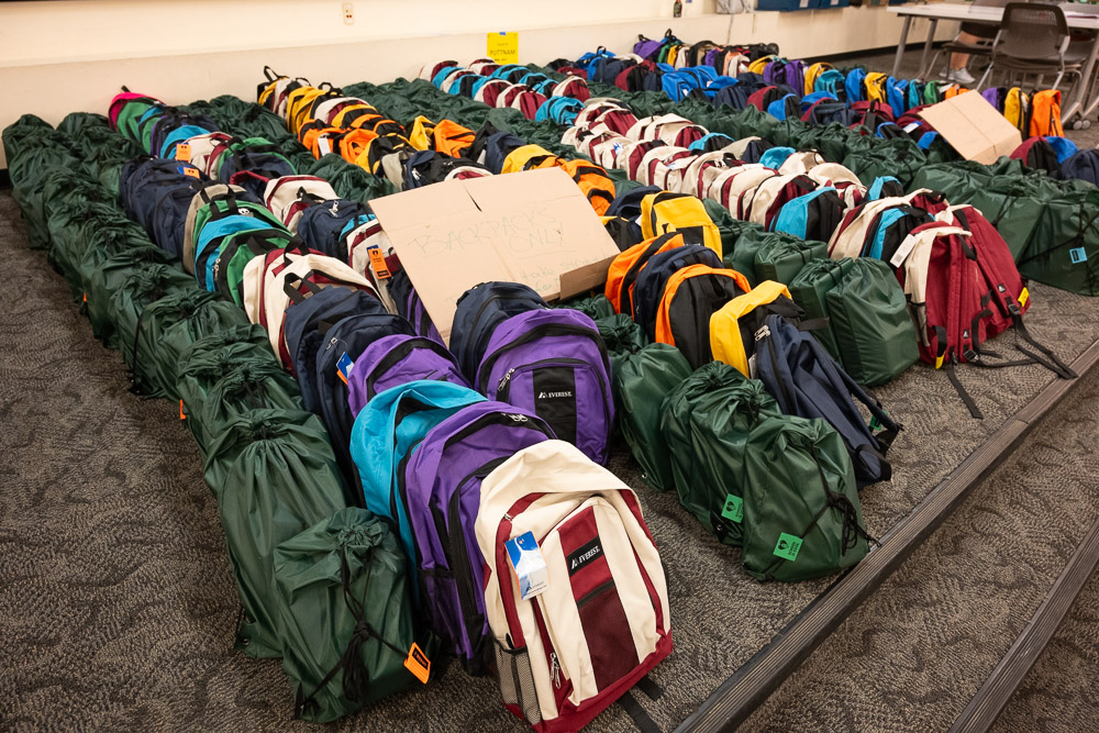 Volunteers load backpacks filled with school supplies to be distributed to local schools as part of School is Cool. August 10, 2023