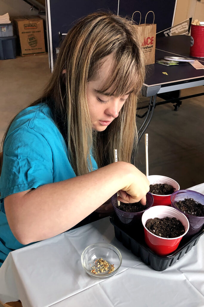 RAM Scholar Anika Pounds working on seeds in cups.