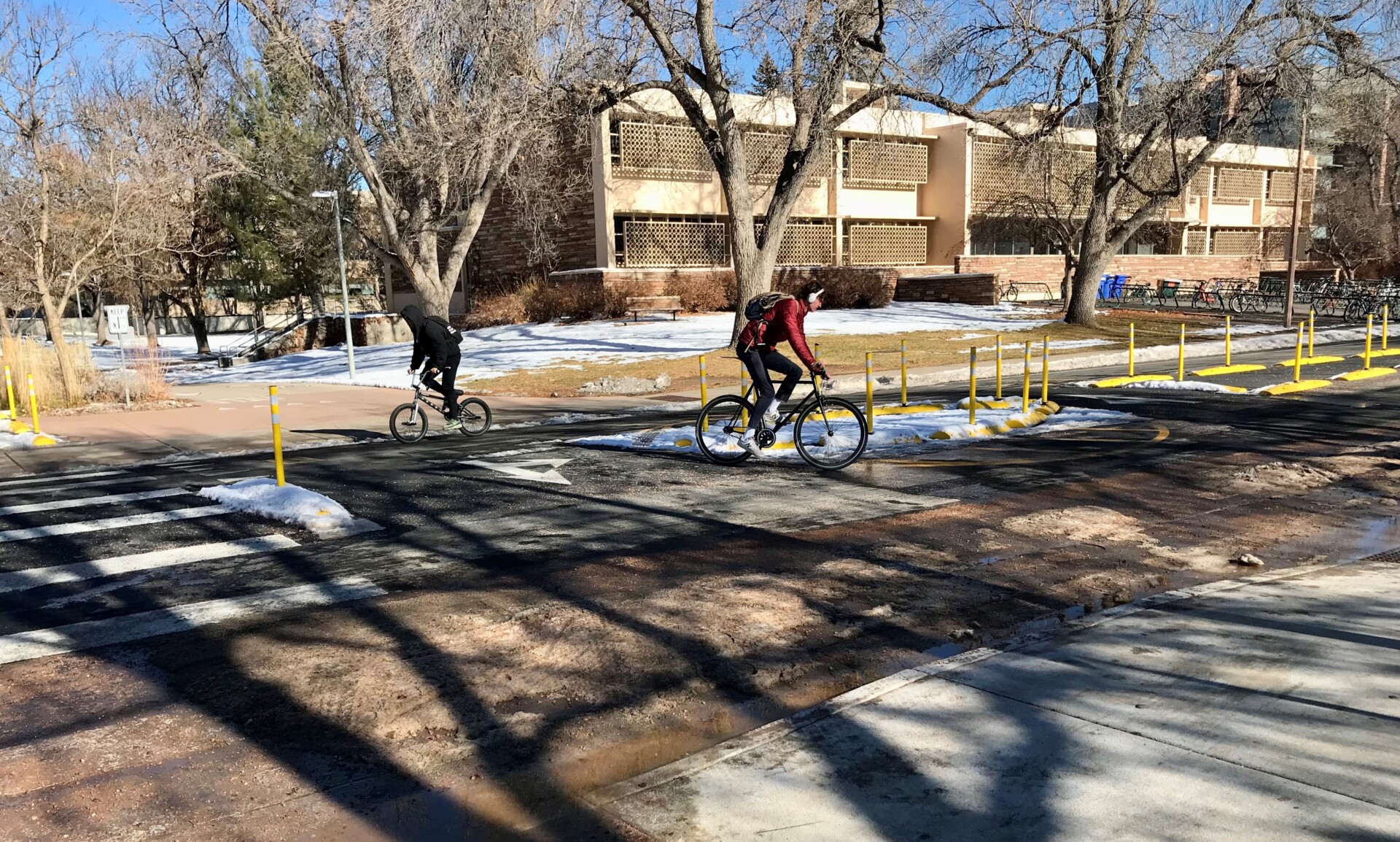Two bicyclists turn opposite directions though marked roundabout