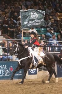 Woman riding horse with CSU flag