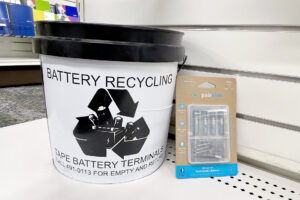 A battery recycling bucket sits next to a pack of Paleblue rechargeable batteries inside the CSU Bookstore.