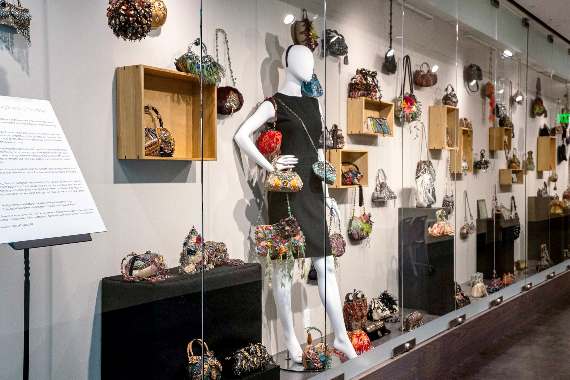 A mannequin with a black dress is in the center of a display of Mary Frances handbags on display at CSU's Avenir Museum.
