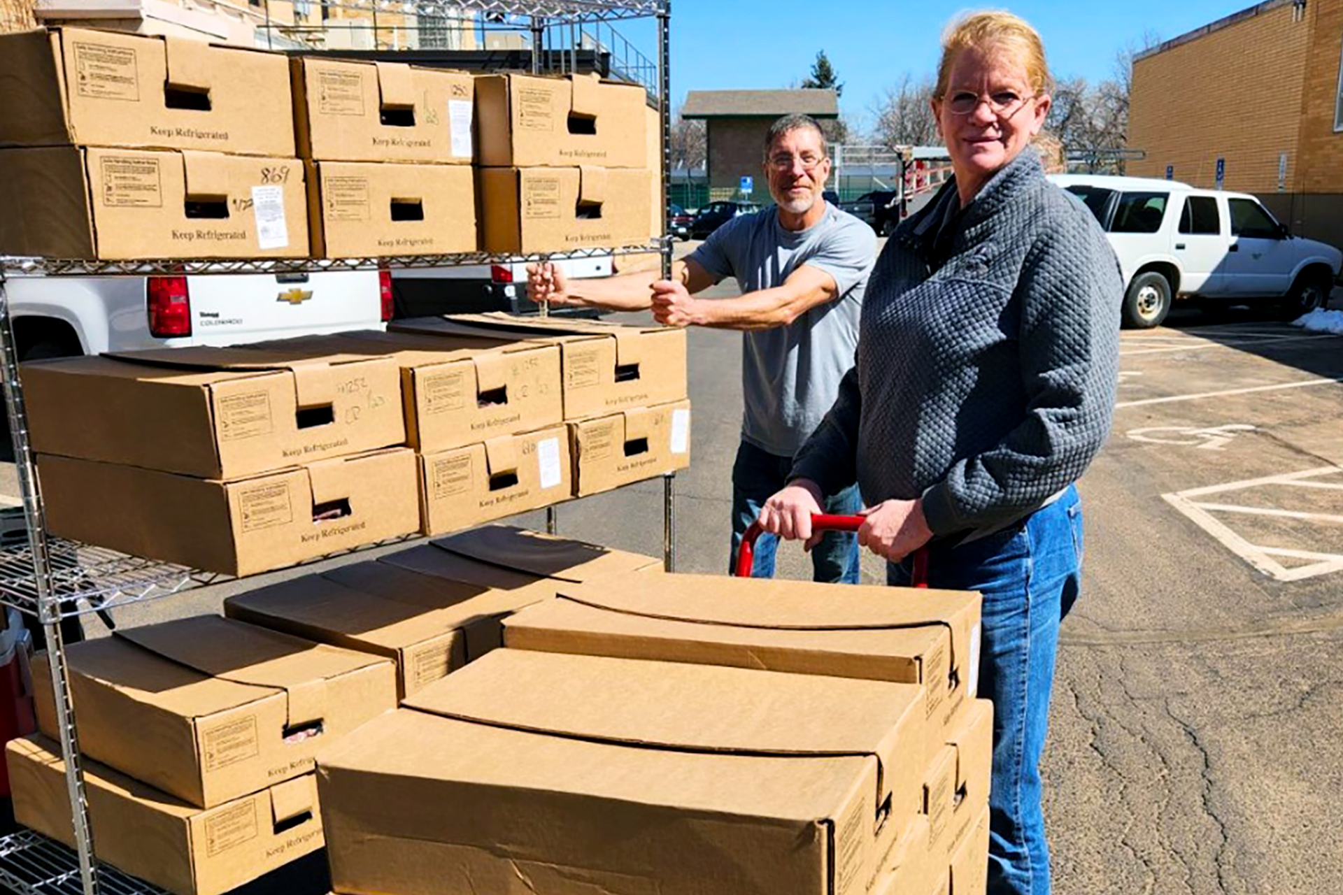 Several boxes of meat are the focus as Christensen Ranch's Kathy Wood (right) and CSU's Michael Buttram move the boxes. The food was donated to the Rams Against Hunger Food Pantry.